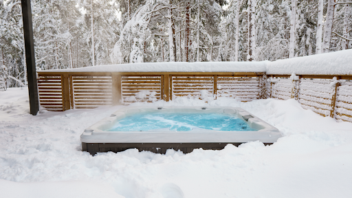 A hot tub bubbles on a snow-covered patio.