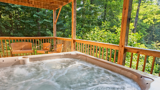 A close-up view of a hot tub with water jets on, surrounded by lush greenery.